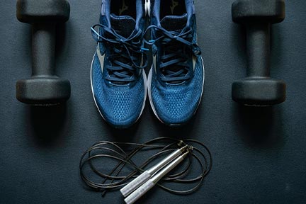 blue running shoes, black jump rope, two black dumbbells laid out for exercising as a truck driver